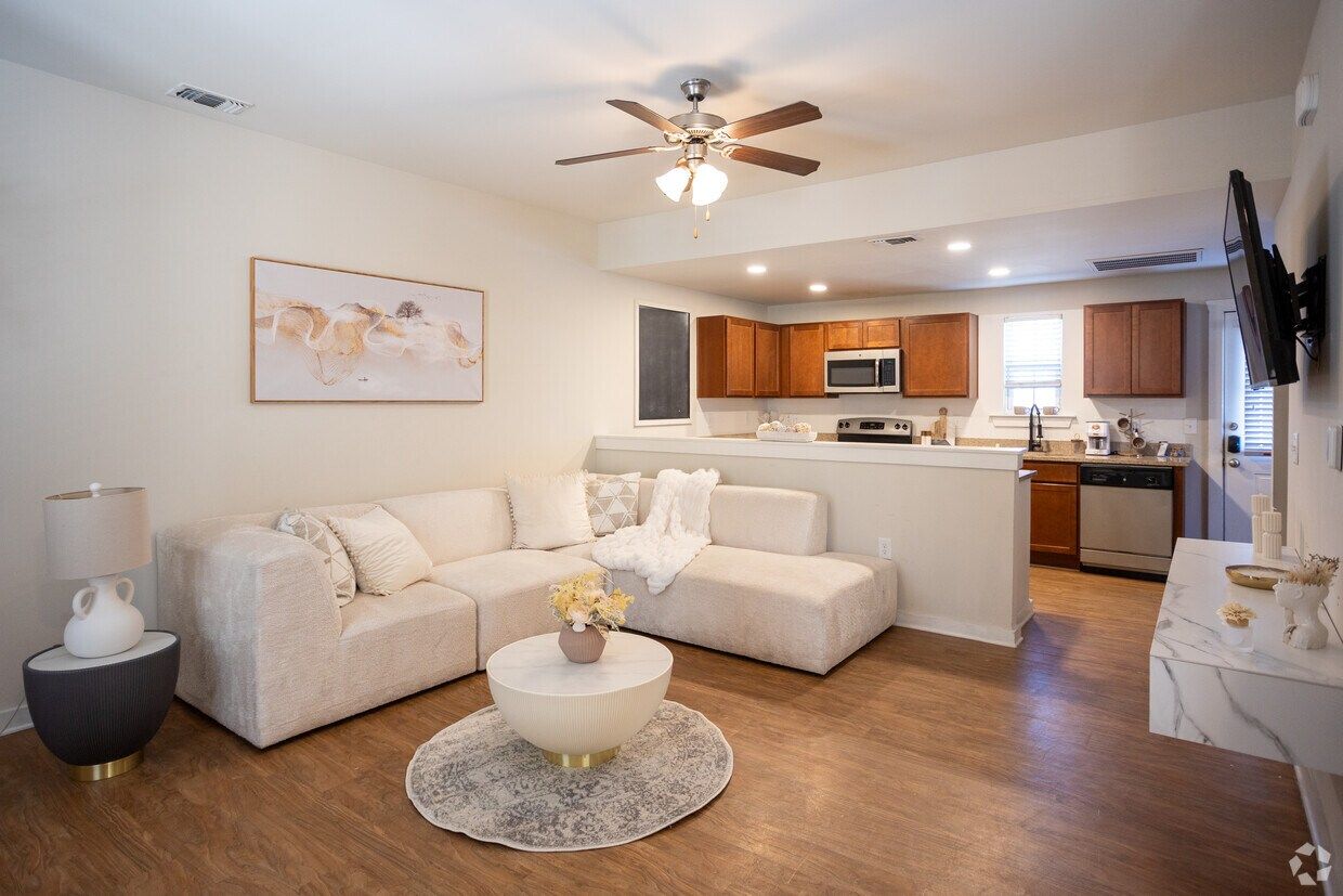 Staged living room with a white sectional, open to the kitchen