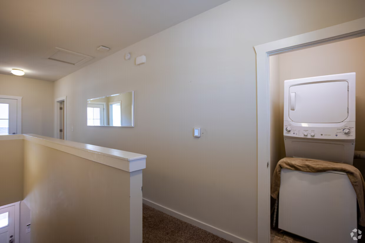 Upstairs hallway with a stacked washer and dryer closet