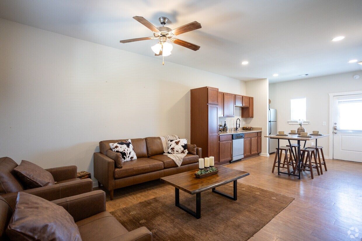 Living room with leather sofas, open to the kitchen and dining area