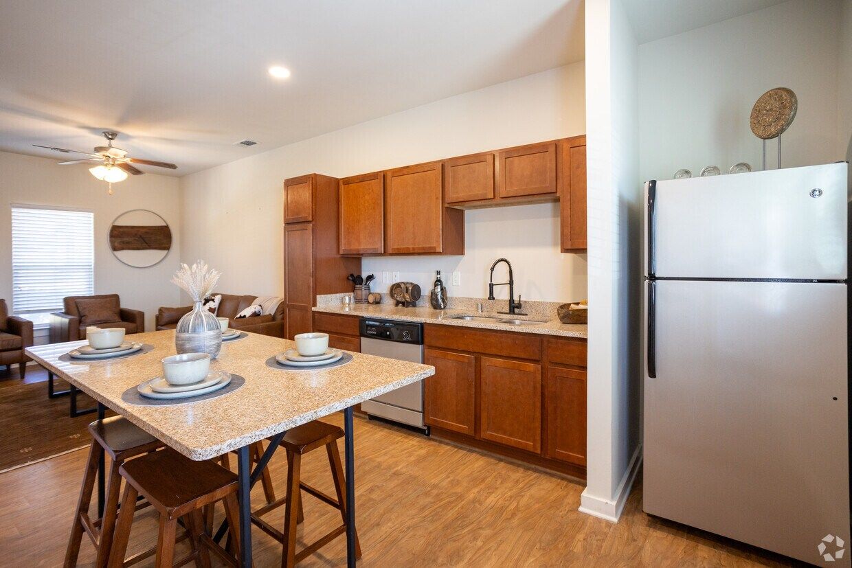 Kitchen and dining area with a granite-top table and stainless refrigerator