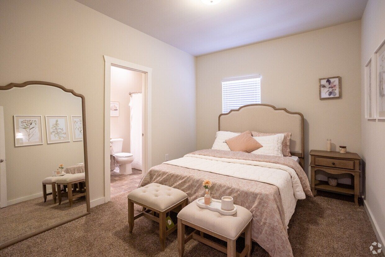 Primary bedroom with an upholstered bed and a private bathroom