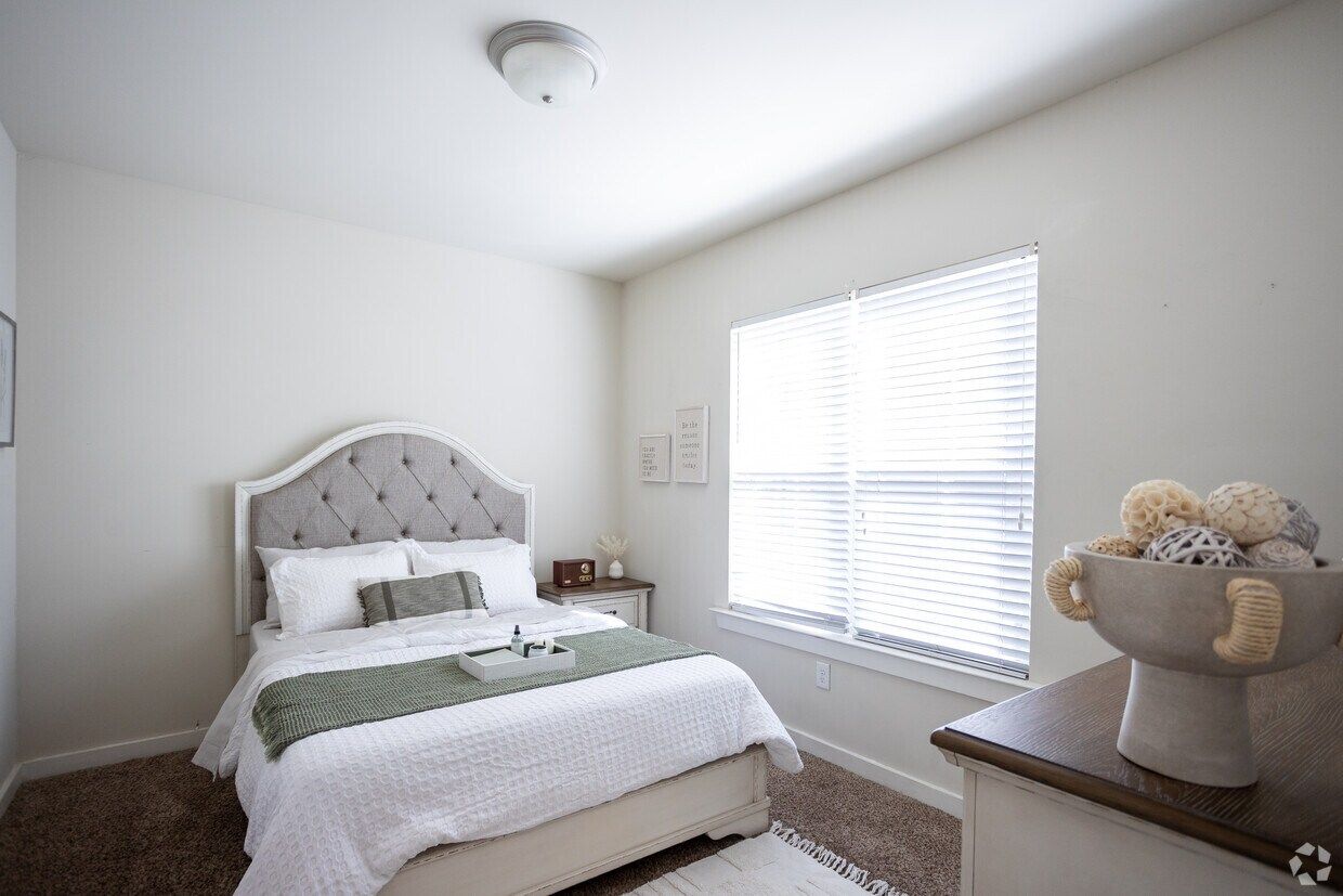 Bright bedroom with a tufted headboard and large window