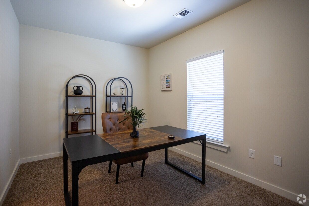 Bedroom staged as a home office with a desk and shelving