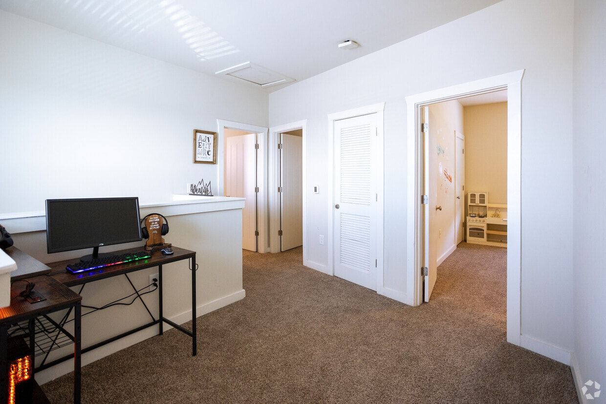 Upstairs loft with a desk area outside the bedrooms
