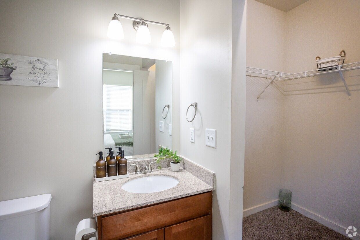 Bathroom vanity next to a walk-in closet
