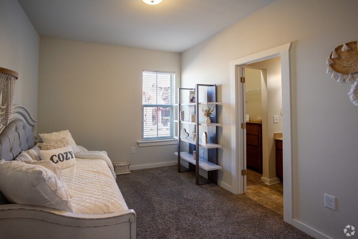 Bedroom with a daybed, shelving, and an attached bathroom