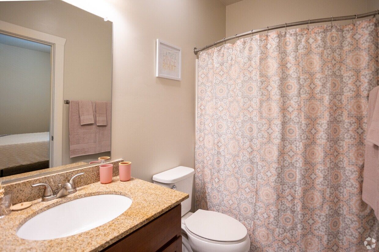 Bathroom with a granite vanity and a tub-shower