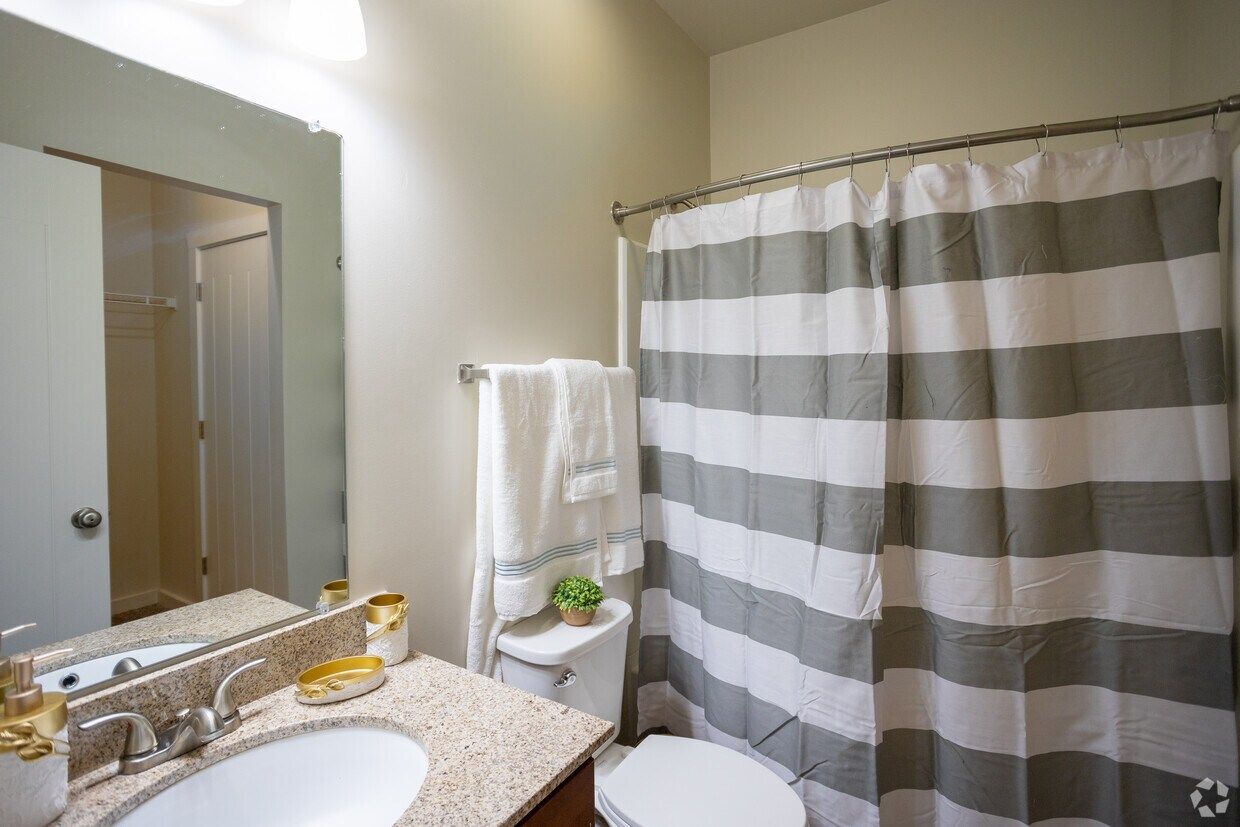Bathroom with a granite vanity and a tub-shower