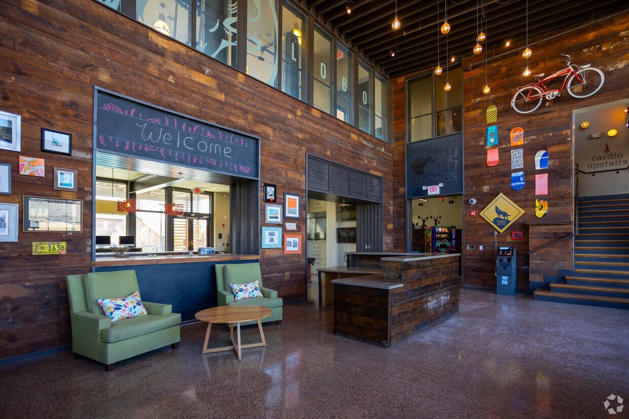 Two-story clubhouse lobby with a welcome desk and lounge seating